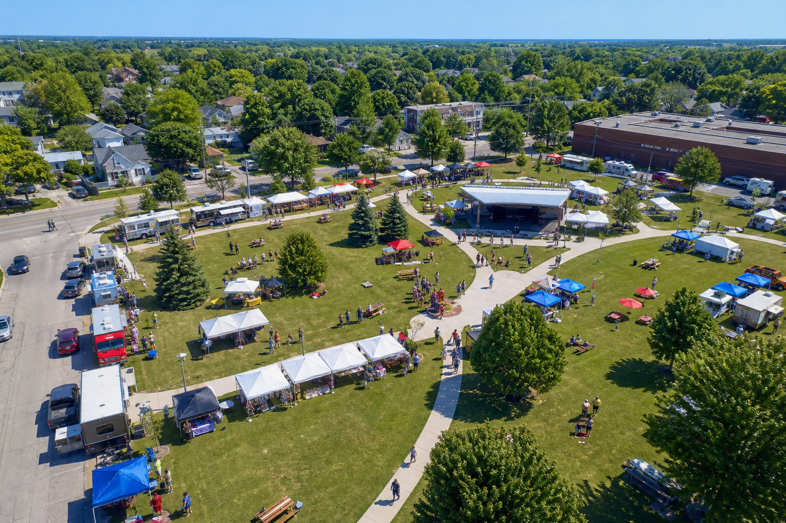 Aerial view of a community festival with vendor tents and park pathways