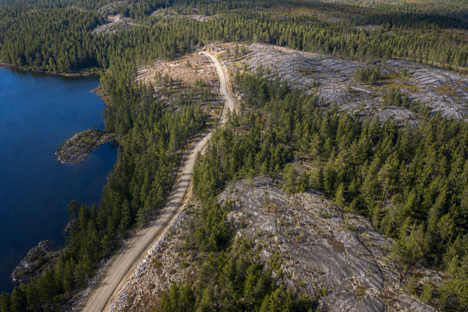 Aerial view of remote Northern Ontario road access through rock and forest
