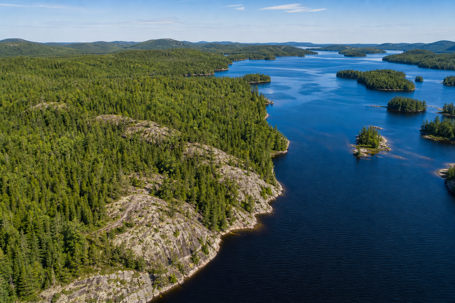 Remote Northern Ontario aerial view of forest, lake, and rocky shoreline
